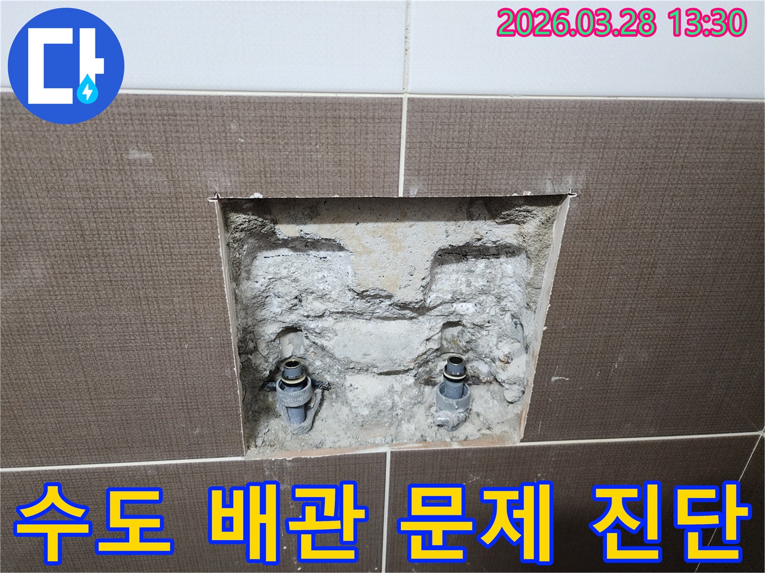 중랑구 묵동 주택의 수도 배관 문제를 진단하기 위해-벽면 타일을 제거하고 내부 배관을 확인하는-공사 현장의 초기 단계입니다.