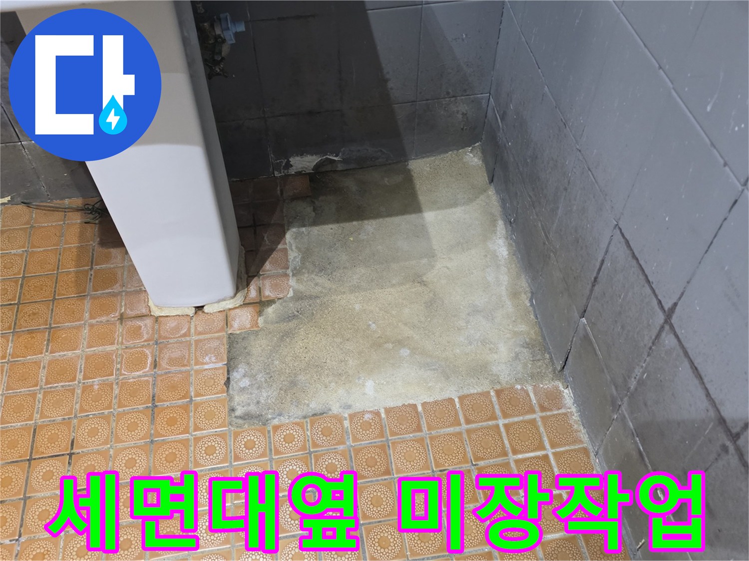 세면대 인근 바닥 타일 굴착 후 미장 작업 모습