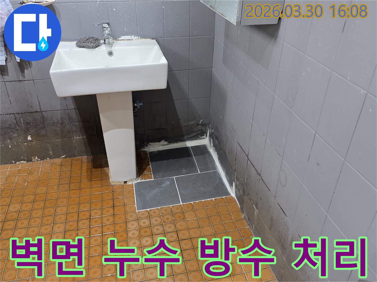 욕실 벽면의-오래된-물자국과-새로 시공된-바닥 타일이-누수 보수-작업의-결과를-보여줍니다.