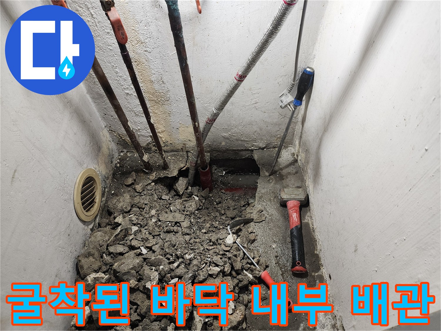 바닥 파쇄 후 드러난 여러 갈래의 배관과 작업 도구