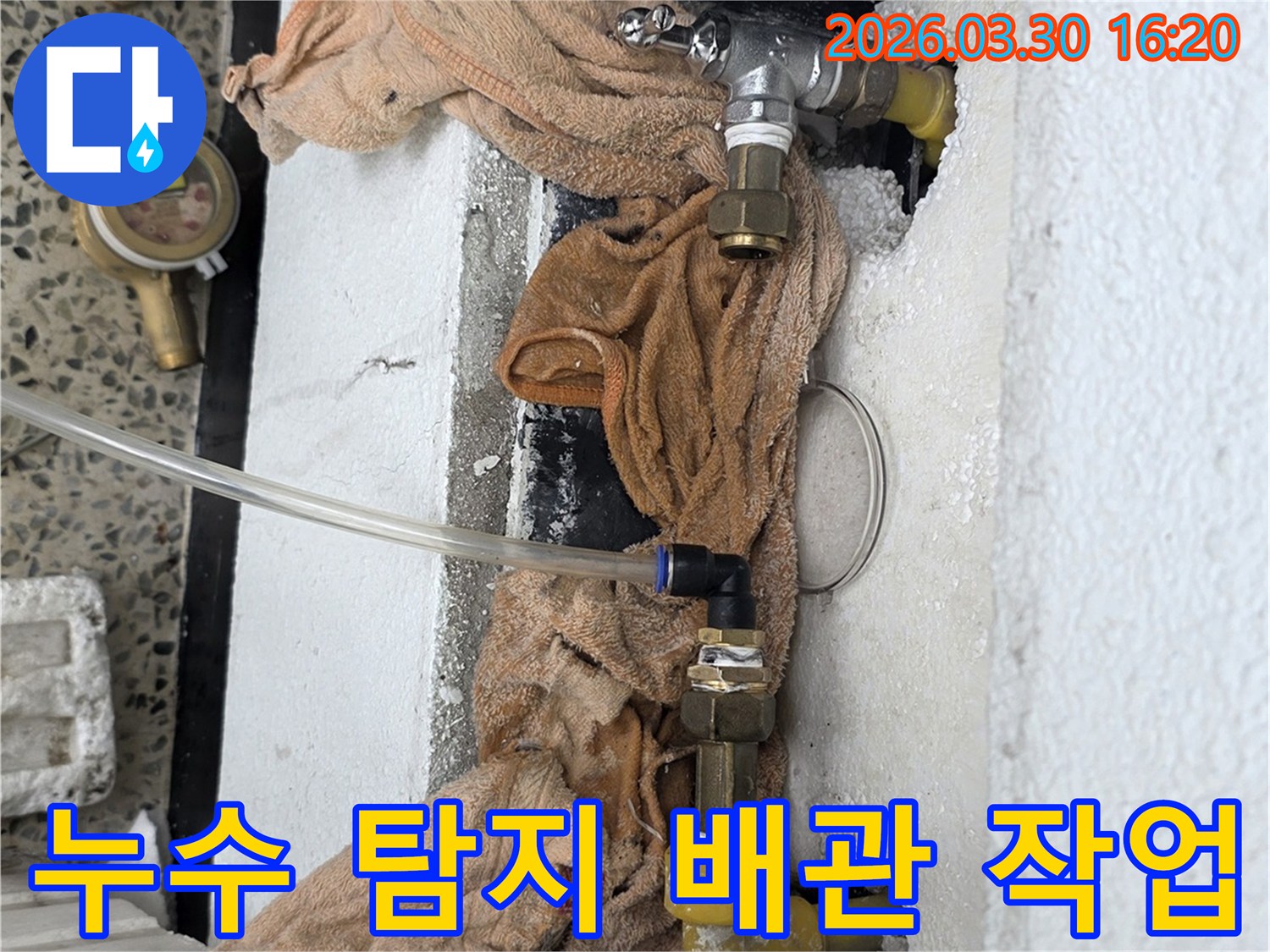 누수 탐지를 위해 배관에 연결된 장비와 주변 환경을 보여주는 사진입니다
