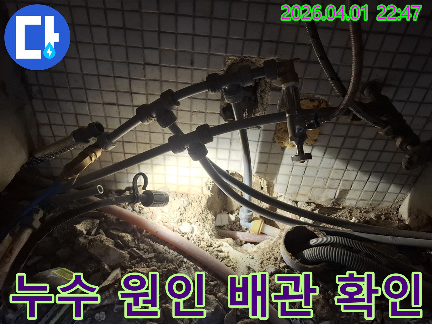 어두운 바닥 아래-누수 원인으로 추정되는-배관을 집중적으로 살펴보는 모습