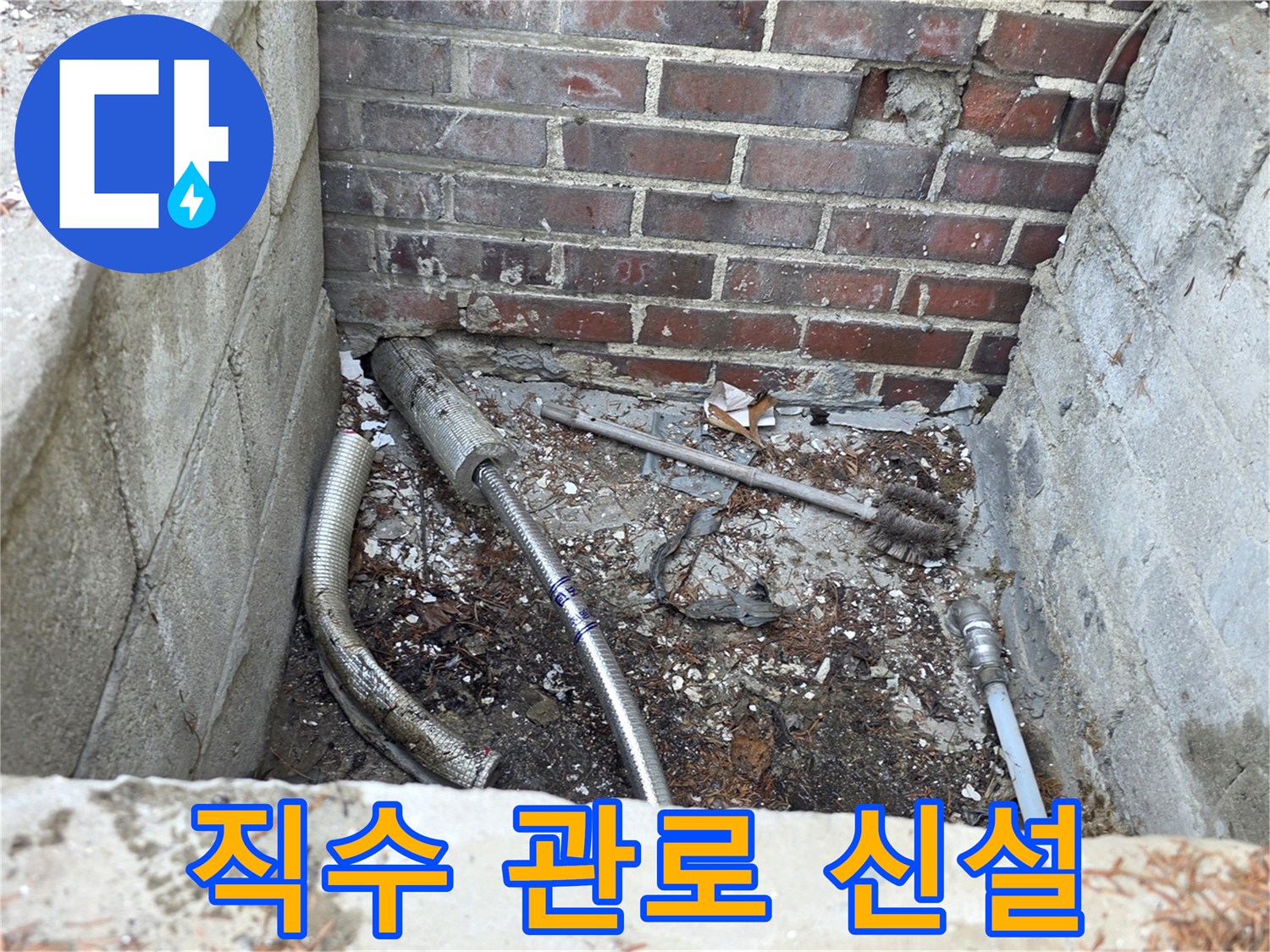 벽돌 벽 아래 흙을 파낸 공간에 설치된 새로운 수도 연결 부위입니다.