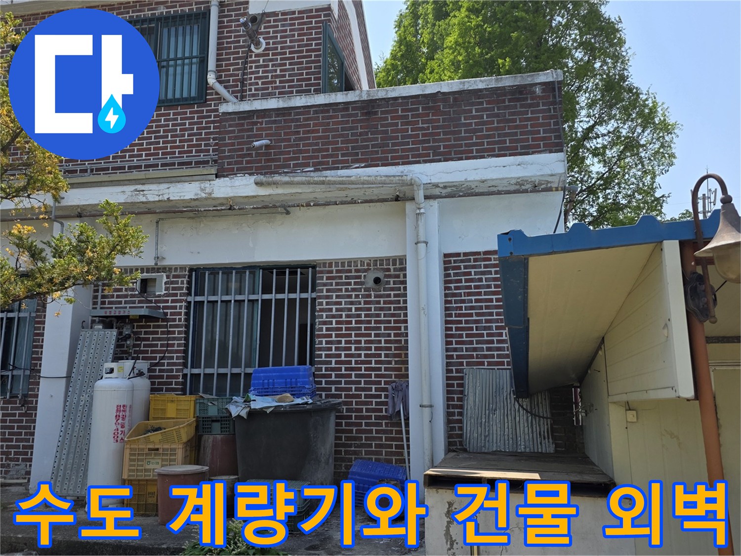 양주 백석읍 건물 외부의 수도 계량기와 벽돌 외벽 근처 배관 모습입니다.