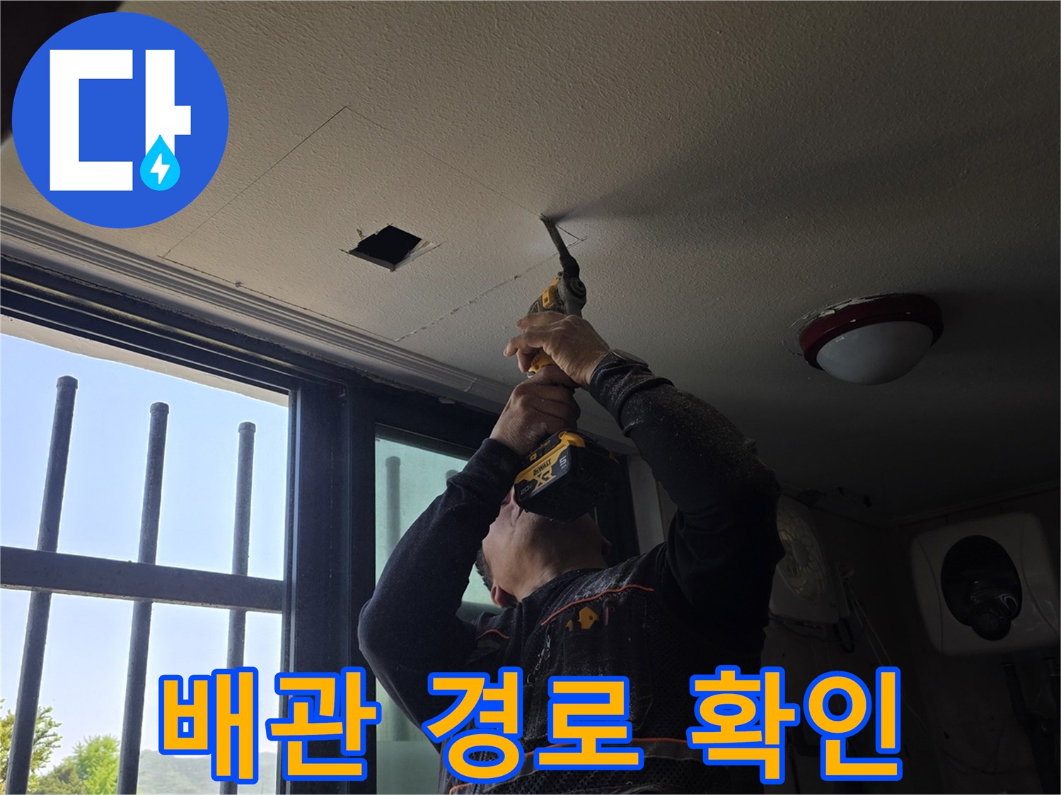 천장 마감재를 뚫어 내부 배관을 살펴보는 엔지니어