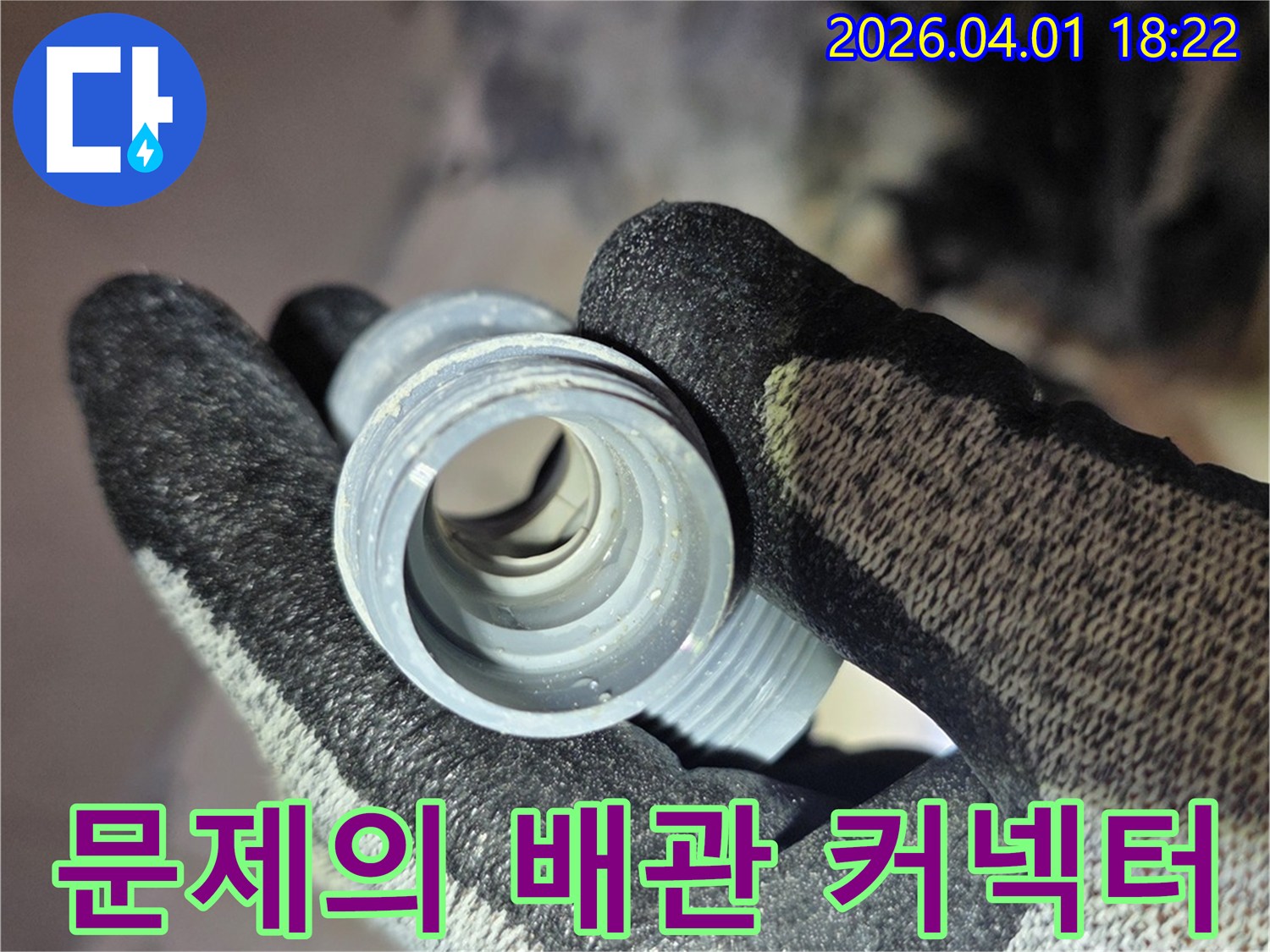 누수 원인이었던-문제의 배관 커넥터를-작업자가 손에 들고-보여주고 있습니다.