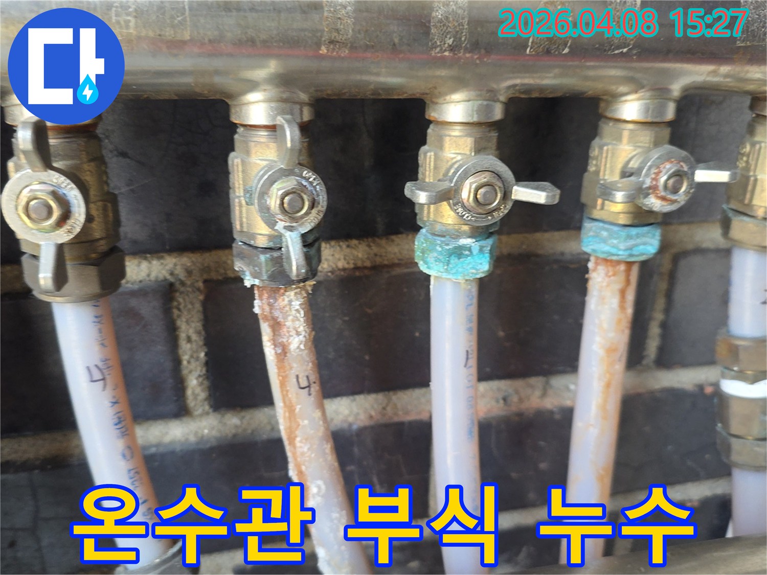 빌라 온수 배관의-밸브 연결 부위에서-심하게 부식되어-누수가 발생한 현장-초록색 녹과-하얀 침전물이-명확하게 보이는 모습