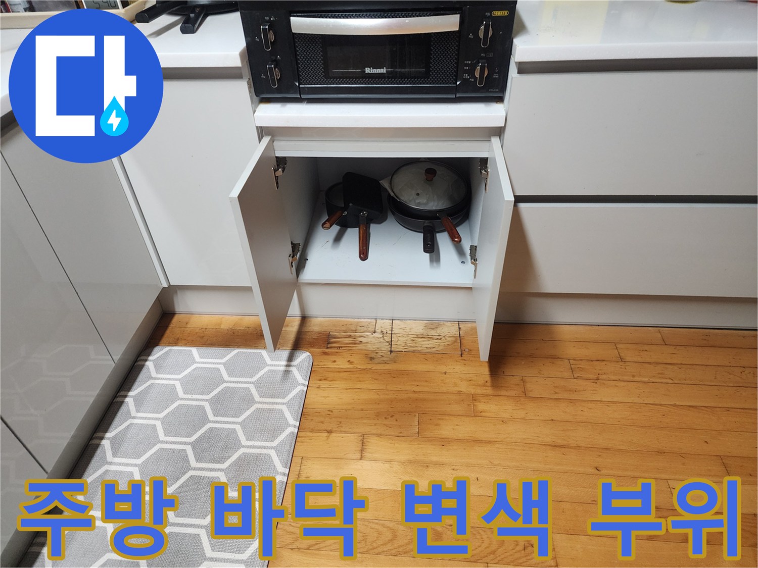 구로구 싱크대 하부장 아래 나무 바닥의 변색된 상태를 보여주는 사진입니다.