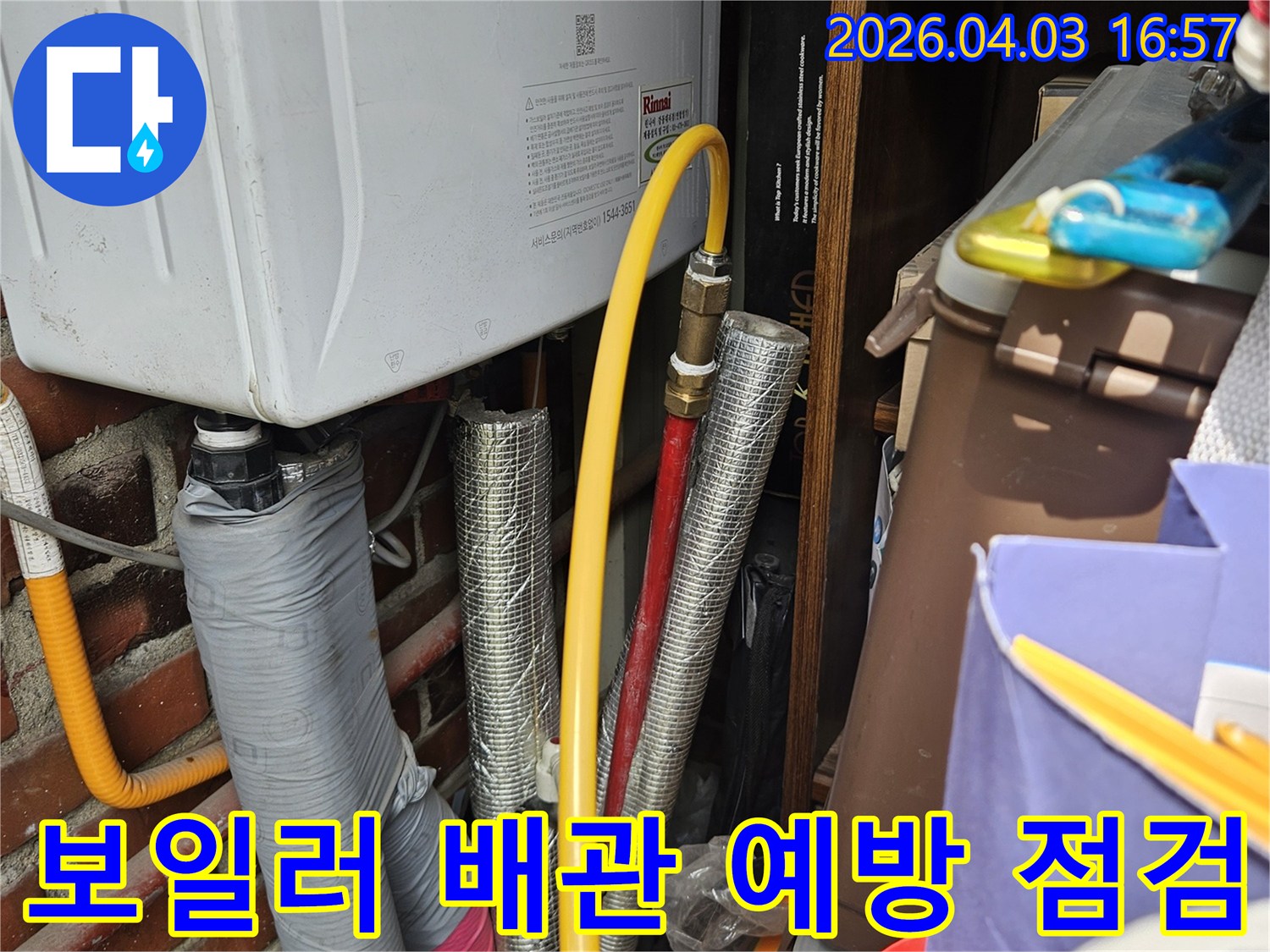 가스 보일러에 연결된 노란색 가스관과 여러 종류의 배관들이 한데 모여 있는 공간입니다-누수 탐지를 위한 초기 육안 검사 장면입니다.