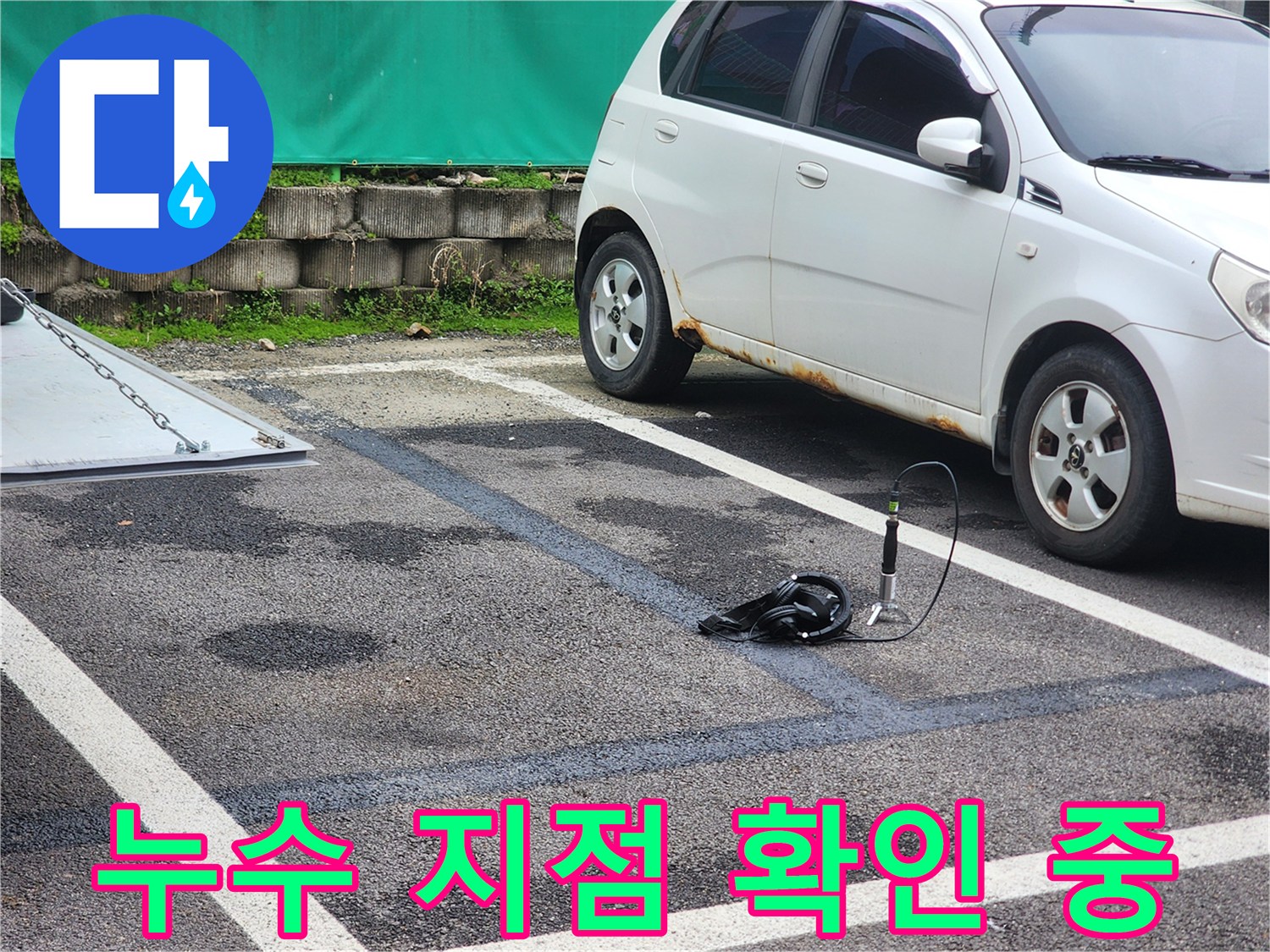 어둡게 젖은 아스팔트 바닥 위에서 작동 중인 배관 진단 장비