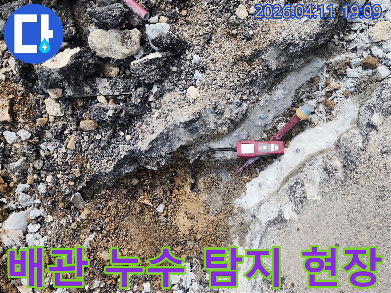 파헤쳐진 땅속에서-붉은색 누수 탐지 장비가-배관 누수 지점을-정확히 가리키고 있습니다