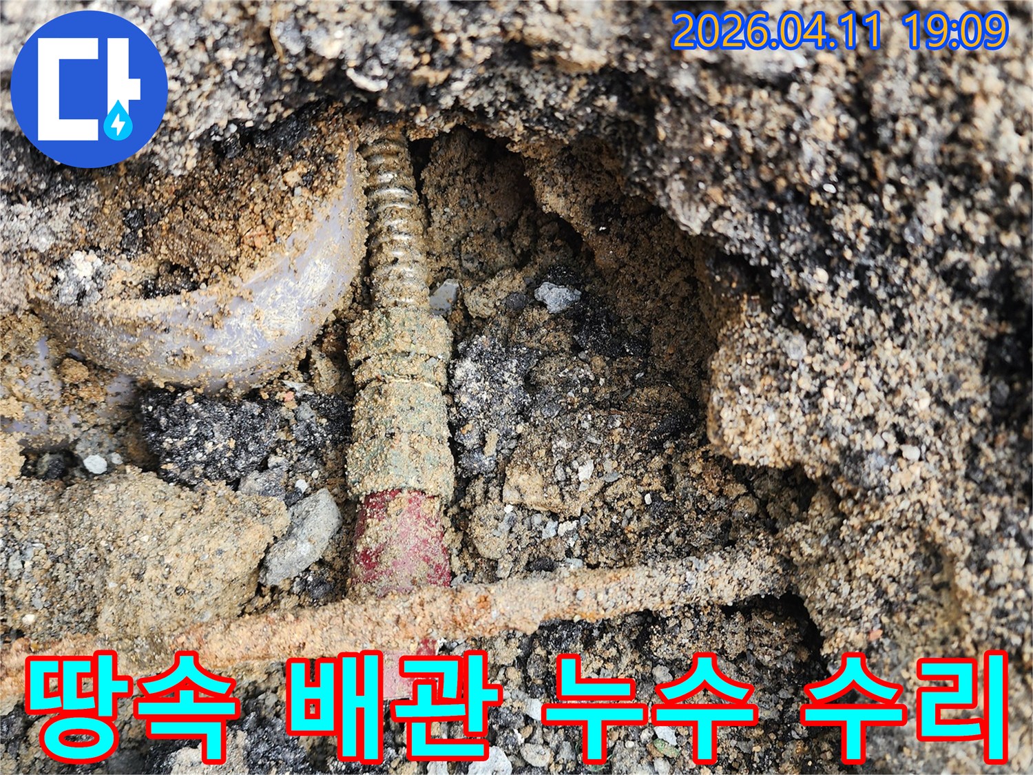 흙 속에-파묻혀 있던-배관에서-누수가 확인되어-수리 작업을-준비하는-모습