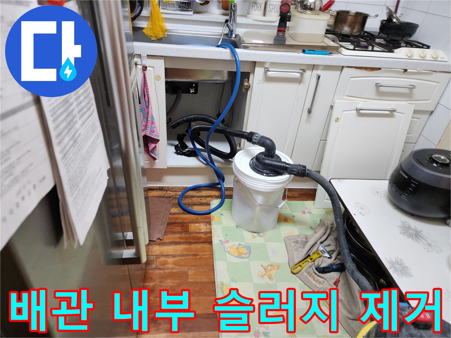 싱크대 배수 호스를 통해 이물질을 빨아들이는 석션기 가동 장면