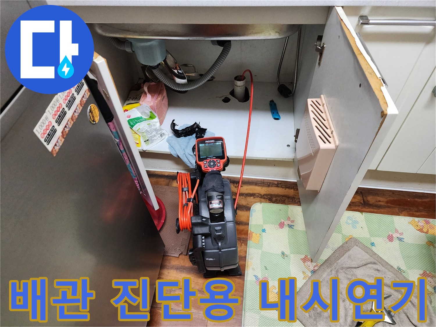 하부장 내부에서 작동 중인 배관 내시경 모니터와 호스