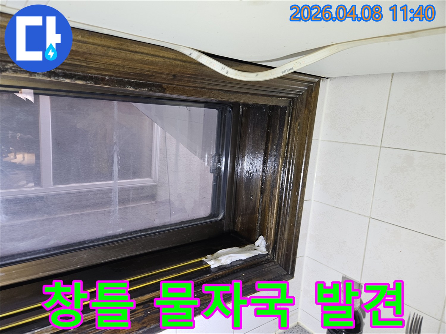 오래된 창틀에서 발견된 물샘-흔적을 보여주는 이미지로-누수 전문가가 현장을 점검하고 있습니다.