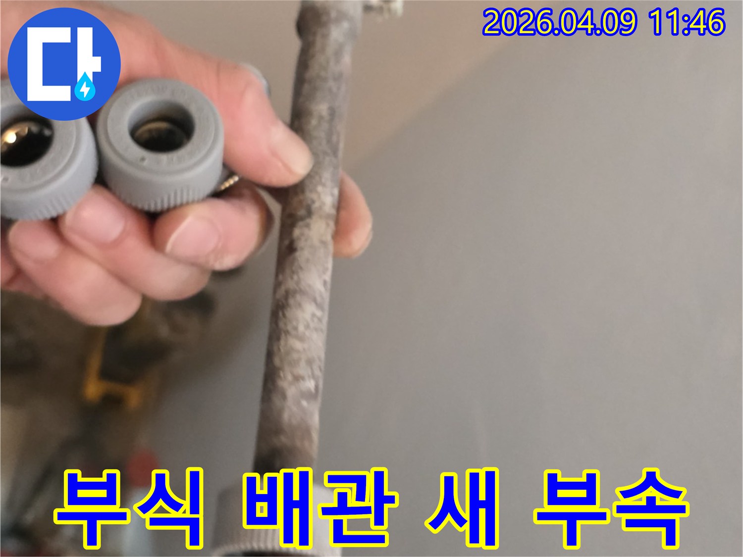 이 사진은-오랜 사용으로 부식된 수도 배관과-교체에 사용될 새 배관 부속을-선명하게 보여줍니다