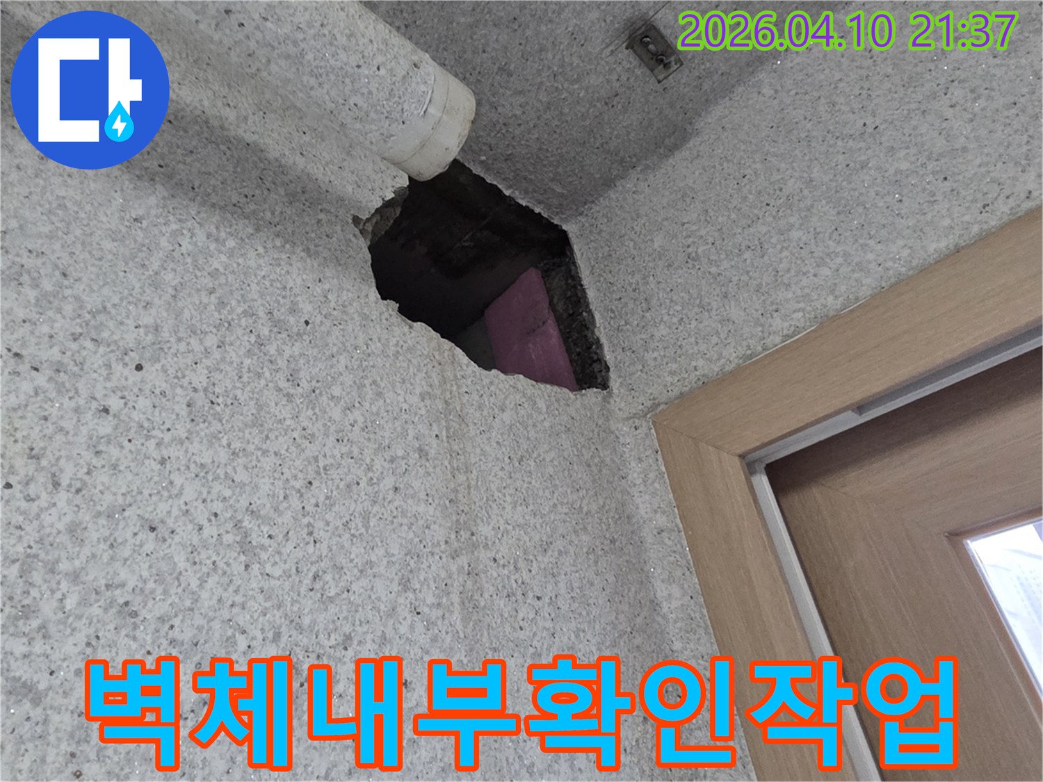 아파트 누수 보수 작업을 위해-벽면을 절개하여 내부 배관을-노출시키고 확인하는 모습입니다.
