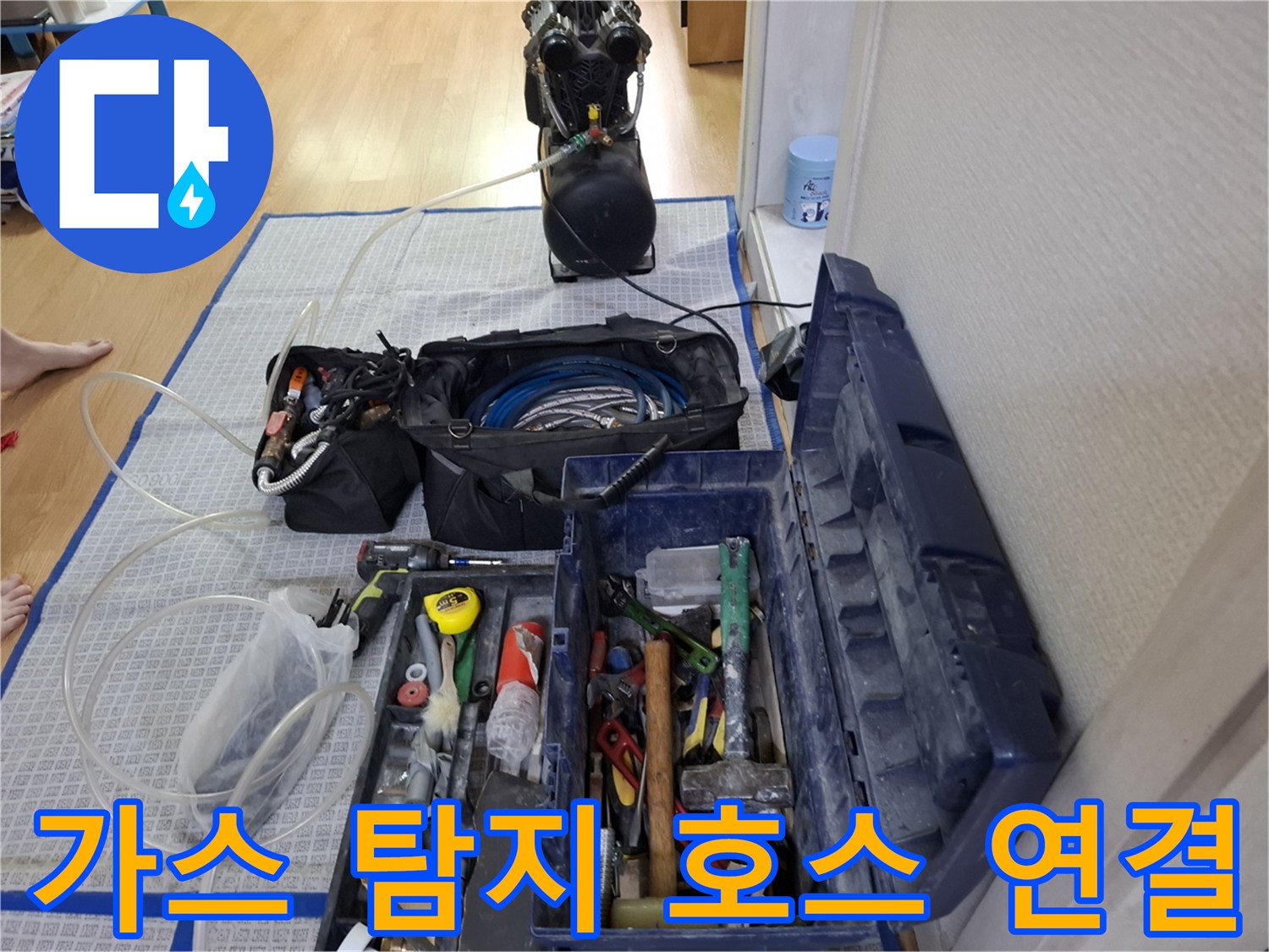 바닥에 배치된 가스 주입용 호스와 전문 공구함-누수 진단 준비