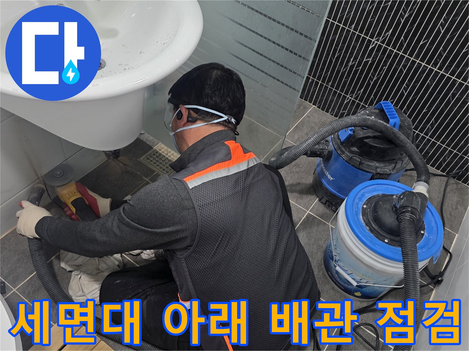 세면대 하단 바닥 부근에서 진행되는 누수 진단 작업 현장