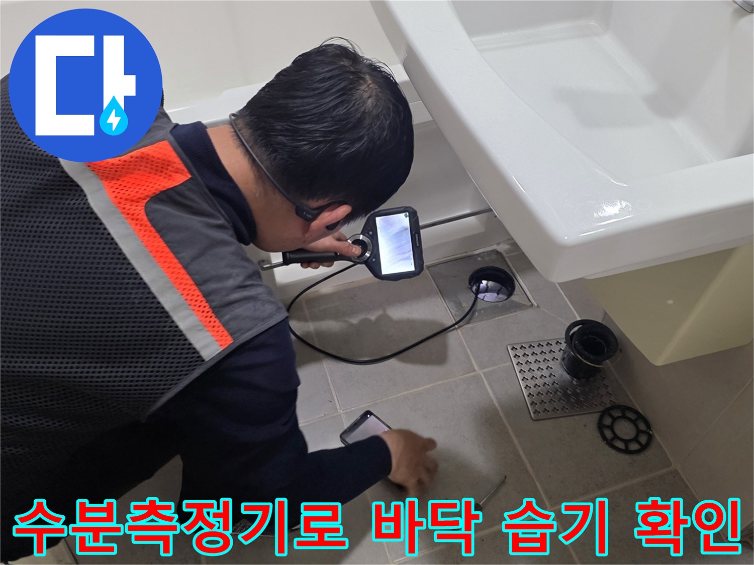 엔지니어가 수분 측정기를 사용하여 화장실 타일 바닥의 습도를 체크하고 있습니다.