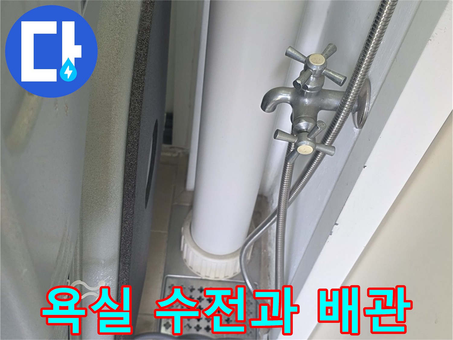 욕실 벽면에 설치된 은색 수전과 연결된 급수 호스 모습
