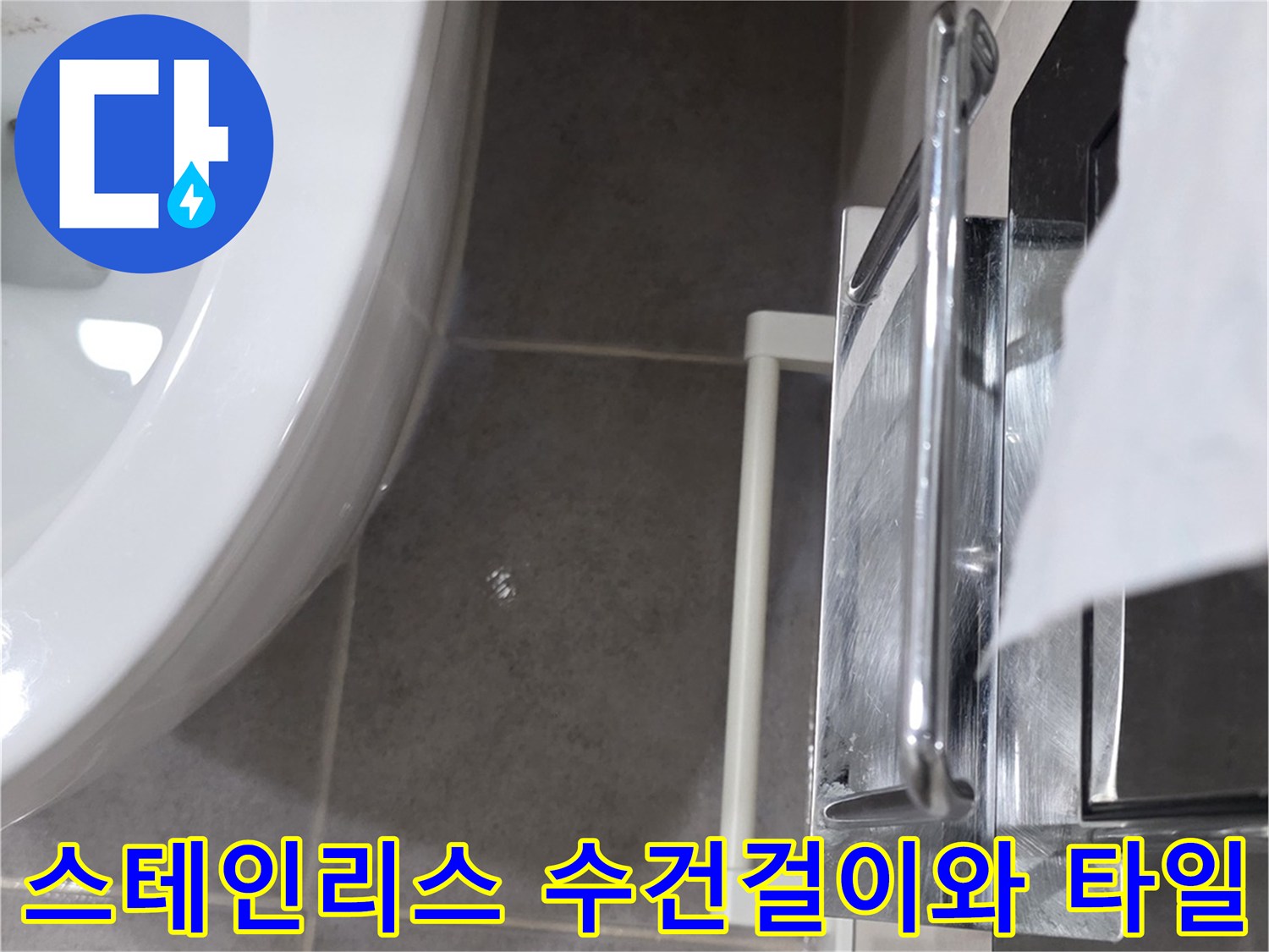 화장실 내부의-금속제 수건걸이와 회색 타일 벽면