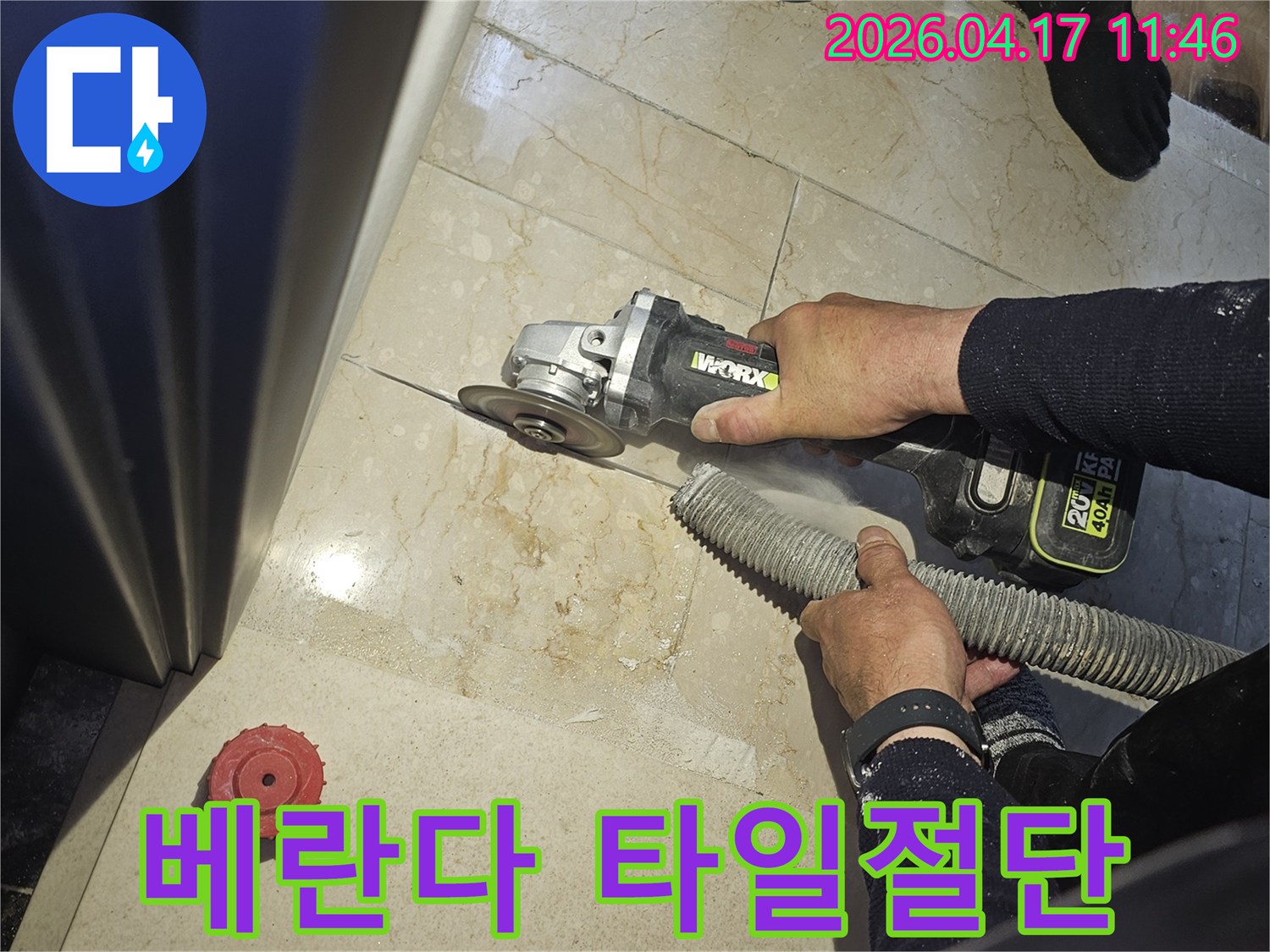 베란다 누수 해결을 위해 작업자가 그라인더로 바닥 타일을 절단하고-있으며-동시에-흡진기로-먼지를-제거하여-깨끗한-작업-환경을-유지하는-모습입니다.
