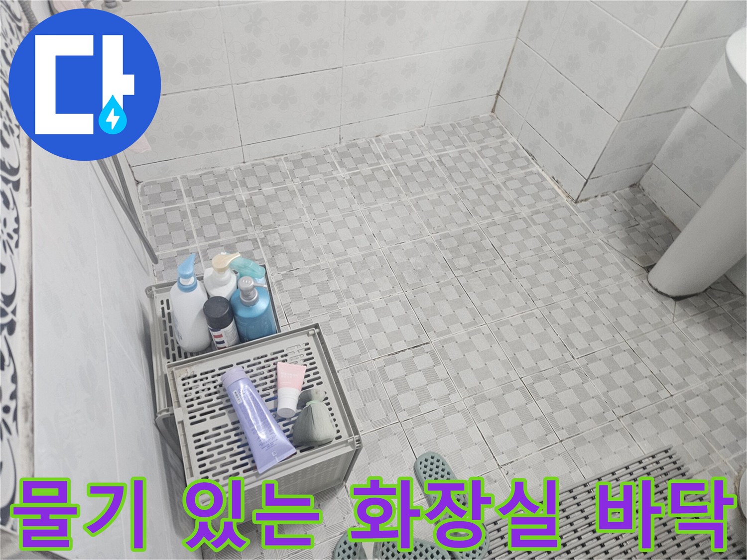 물기가 남아있는 욕실 타일과 세면도구가 담긴 바구니 사진입니다.