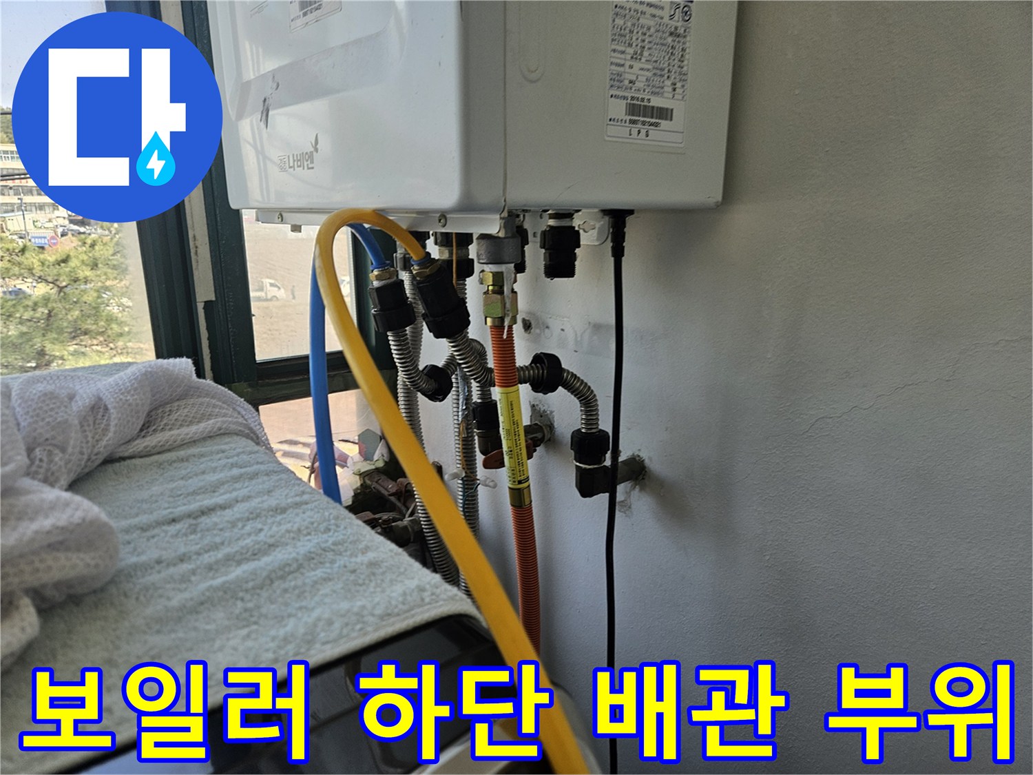 보일러 아래쪽의 노란색과 파란색 배관 연결부 사진입니다.