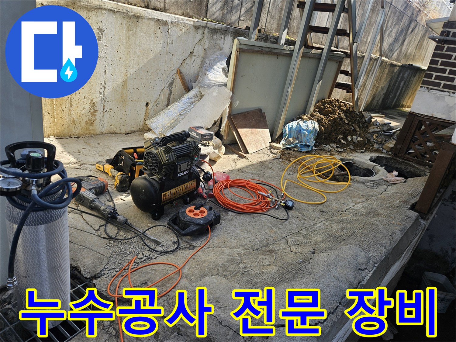 누수 공사 현장에서-에어 콤프레셔-함마드릴-호스-전선릴 등-다양한 전문 장비들이-콘크리트 바닥 위에-정돈되어 있는-작업 준비 현장