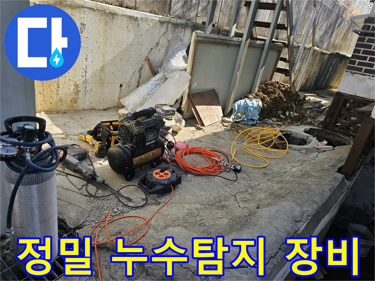 누수 공사를 위한-에어 콤프레셔-함마드릴-호스-전선릴 등-다양한 전문 장비들이-콘크리트 바닥 위에-정돈되어 있는-작업 준비 현장