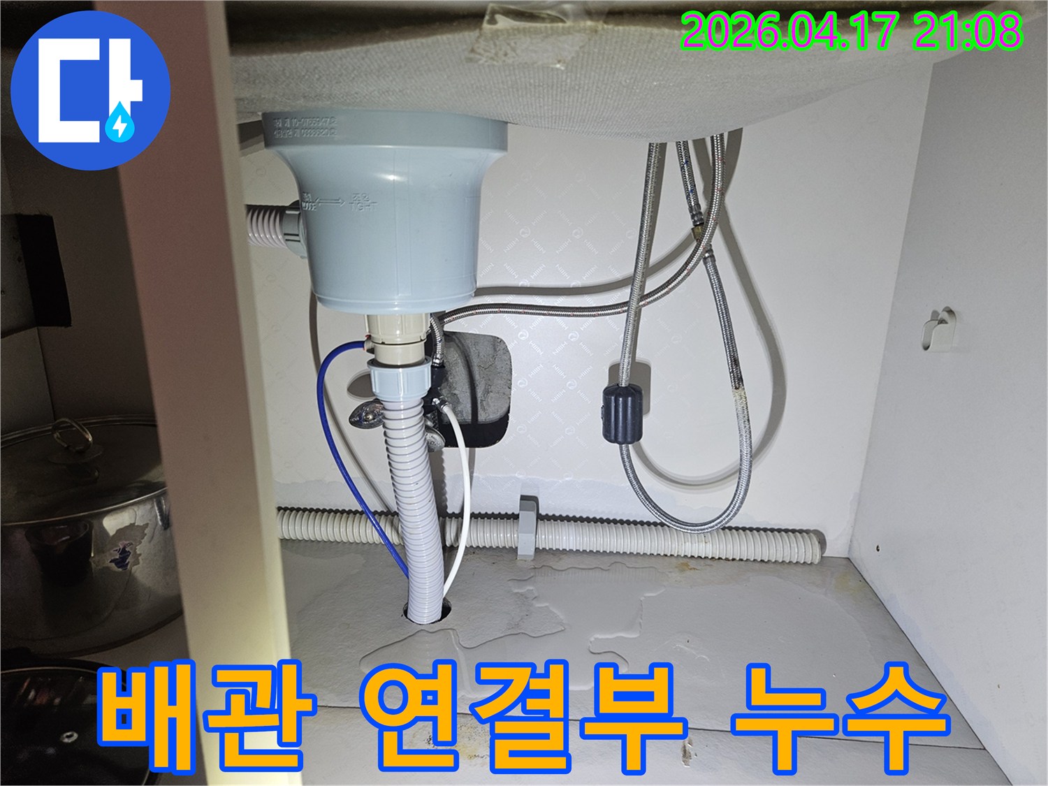 싱크대-아래-배관-연결부에서-물이-새어-나와-바닥을-적시고-있는-사진입니다.