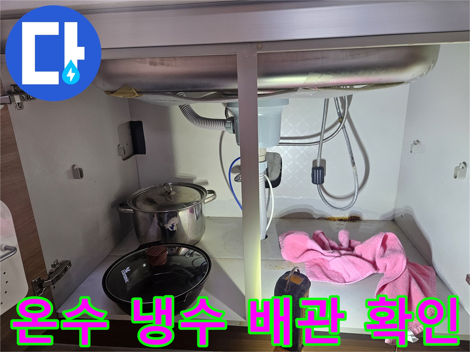 싱크대-하부의-온수-및-냉수-배관에서-누수-여부를-확인하는-전문가의-작업-모습을-보여주는-사진입니다