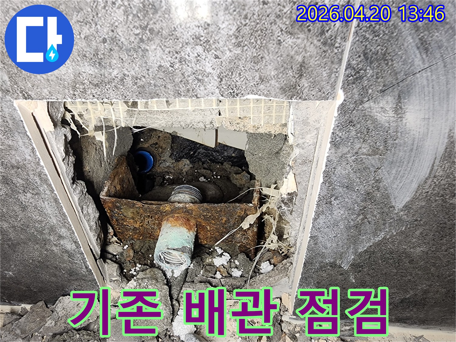 천장 내부의 낡고 부식된 기존 배관의 상태를-교체 작업 전에 면밀히 점검하는 현장 사진입니다.