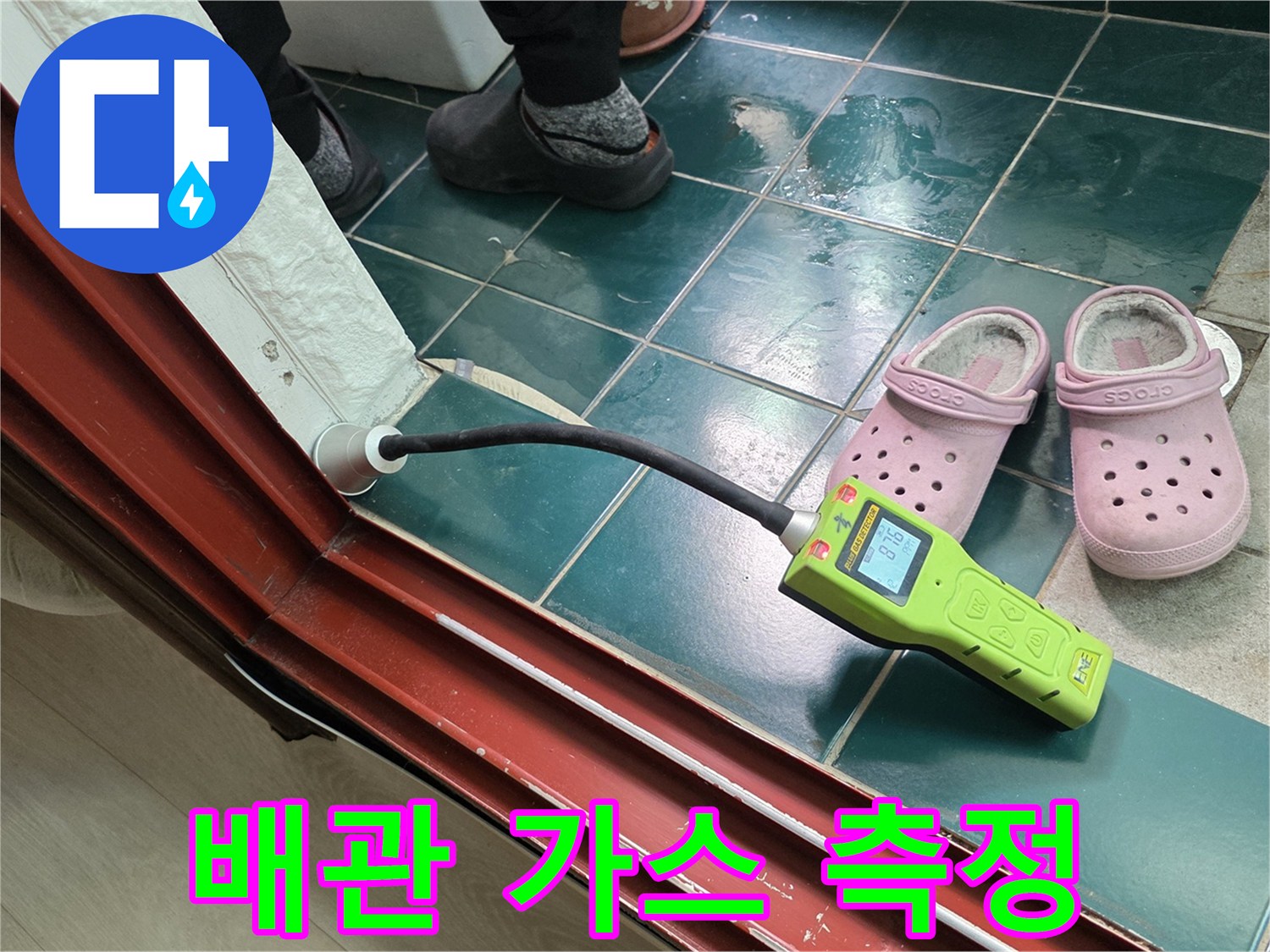 탐지기 호스를 배관 연결 부위에 대고 검사하는 장면입니다.