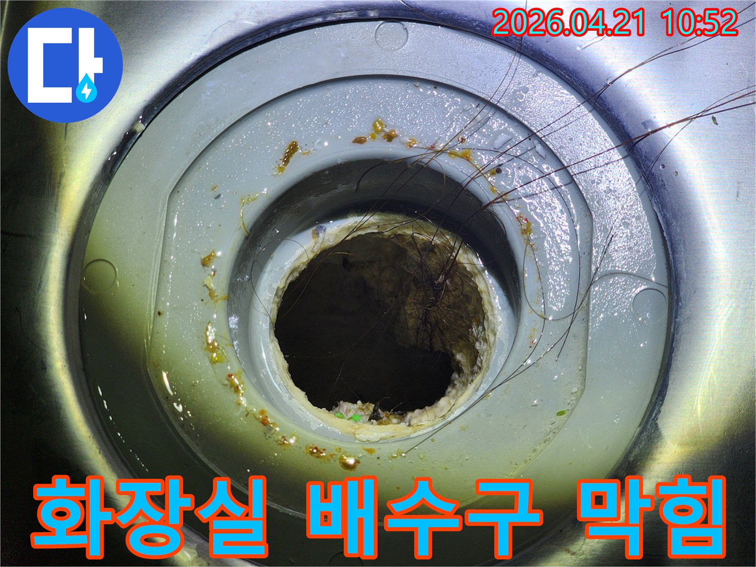 머리카락과 이물질로 심하게 막힌 화장실 배수구의 모습으로-배수 불량과 누수 발생 가능성을 보여줍니다