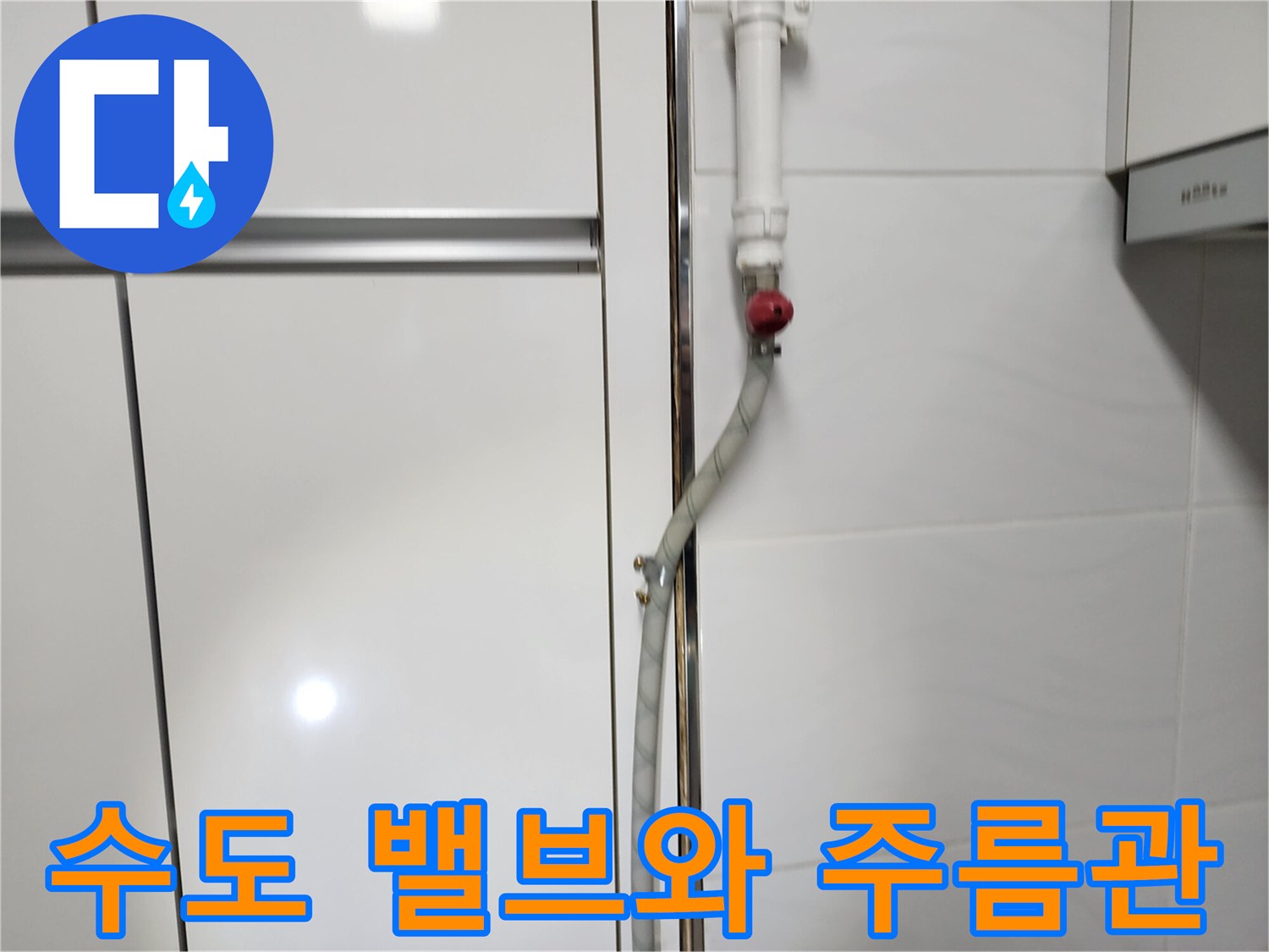 빨간색 밸브가 달린 수도 배관과 은색 주름관의 연결 상태 - 누수 점검 중