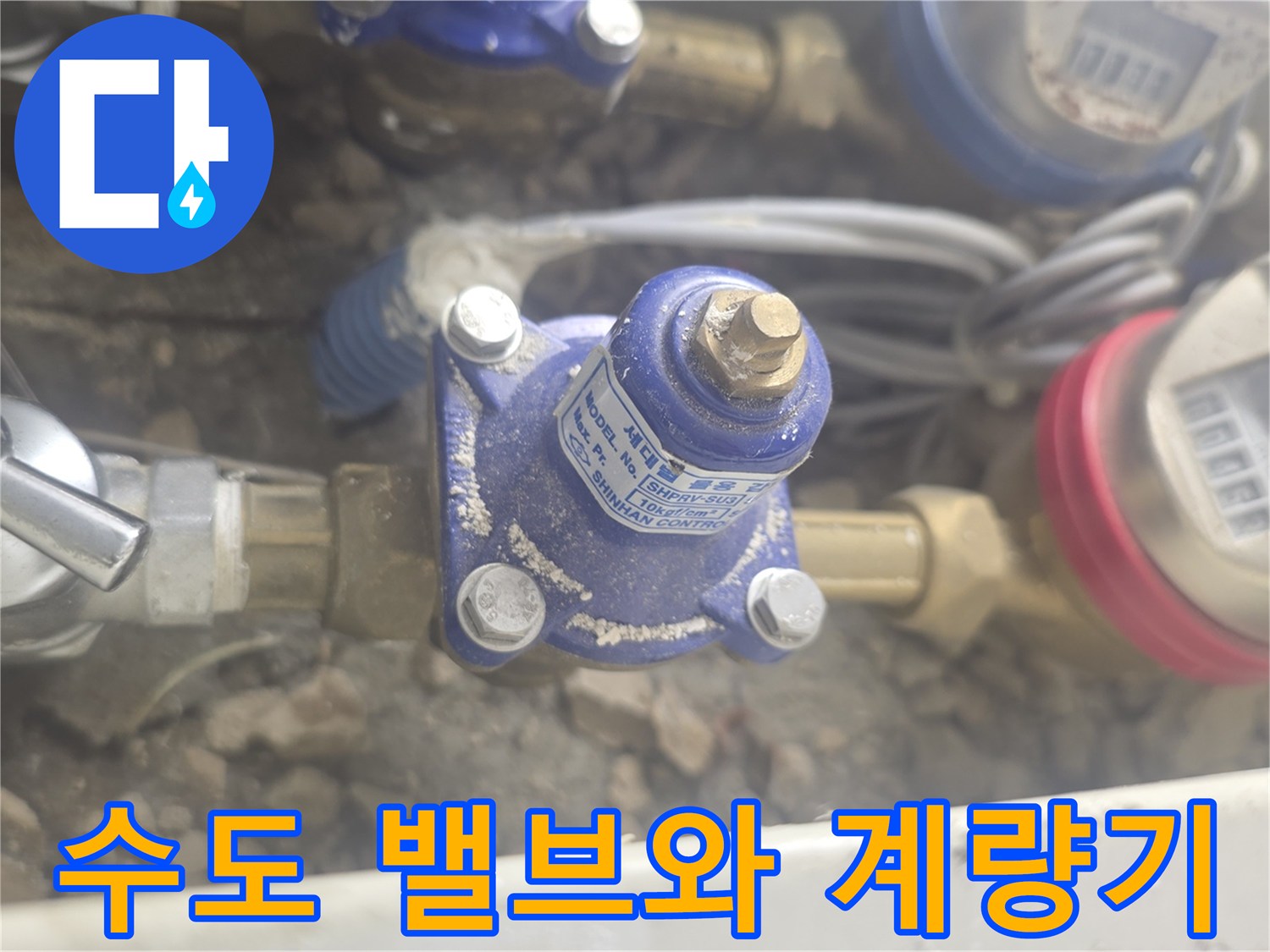수도 계량기와 금속 재질의 밸브가 연결된 배관 모습입니다.