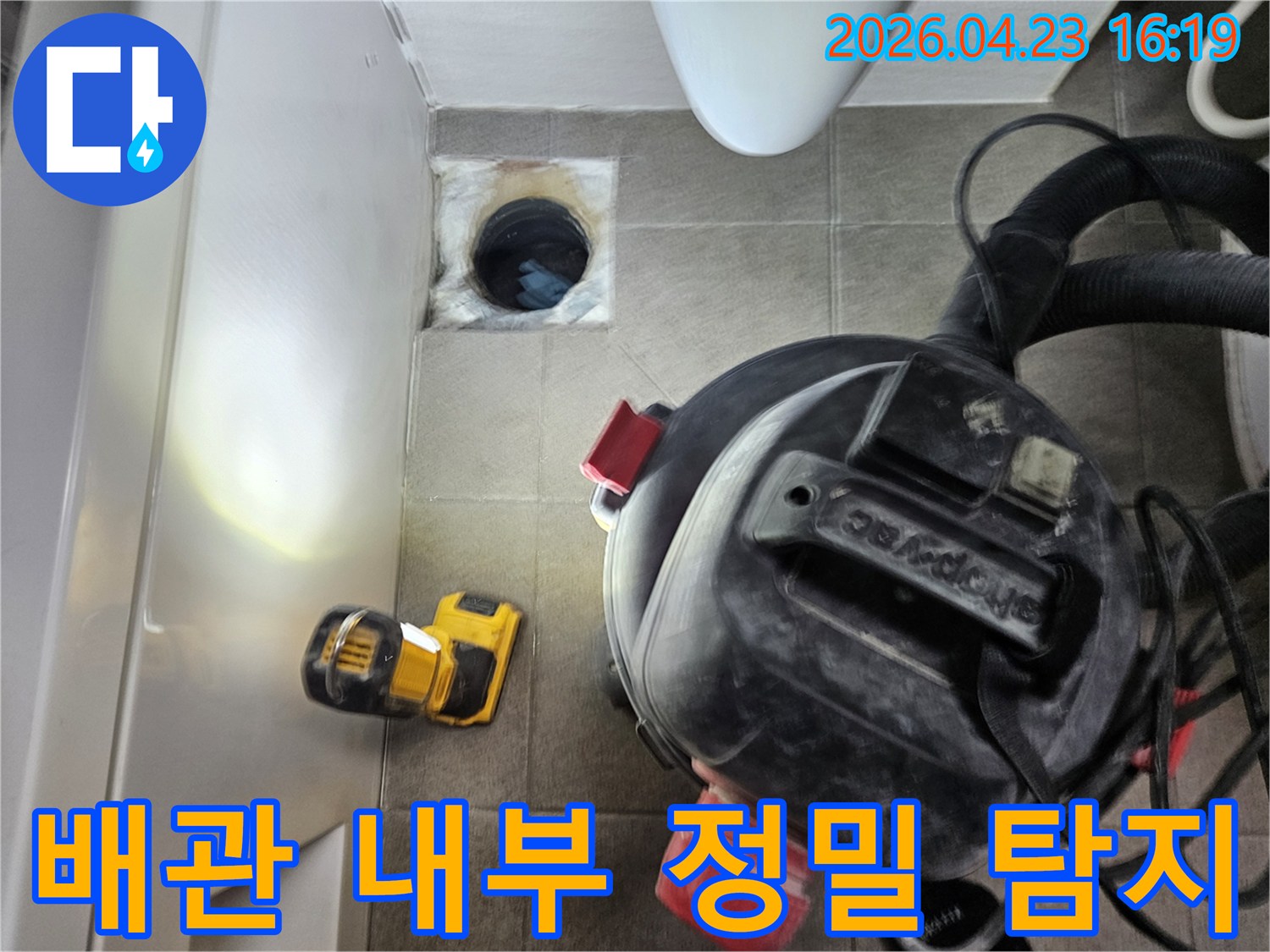 누수 엔지니어가-오산시티자이2차-아파트 욕실의-어두운 배관 속을-손전등으로-밝히며-누수 원인을-찾는-모습