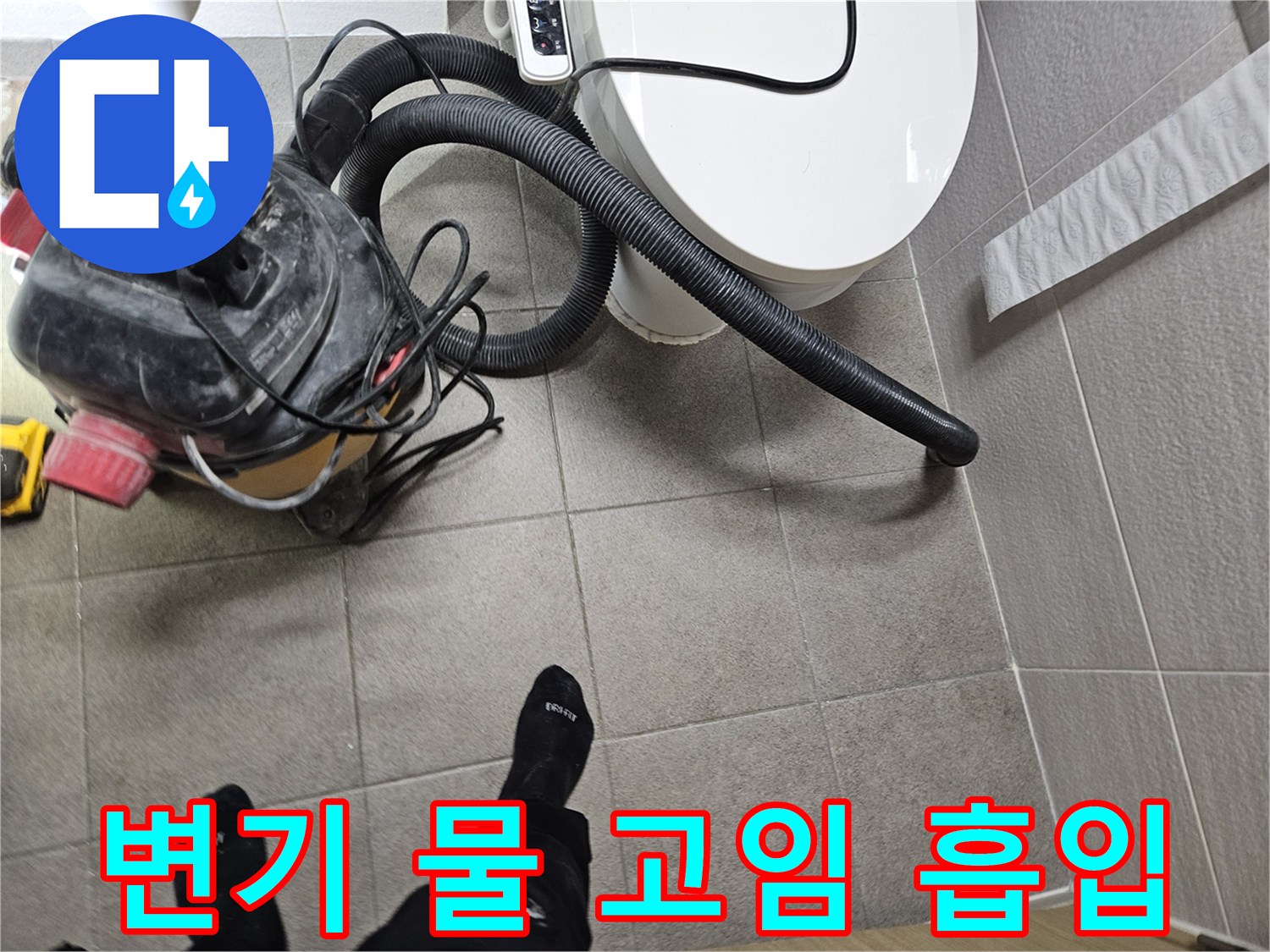 오산시 아파트 화장실에서-누수 엔지니어가-변기 주변에 고인 물을-습식 청소기로 흡입하여-누수 현장을 정리하는 모습