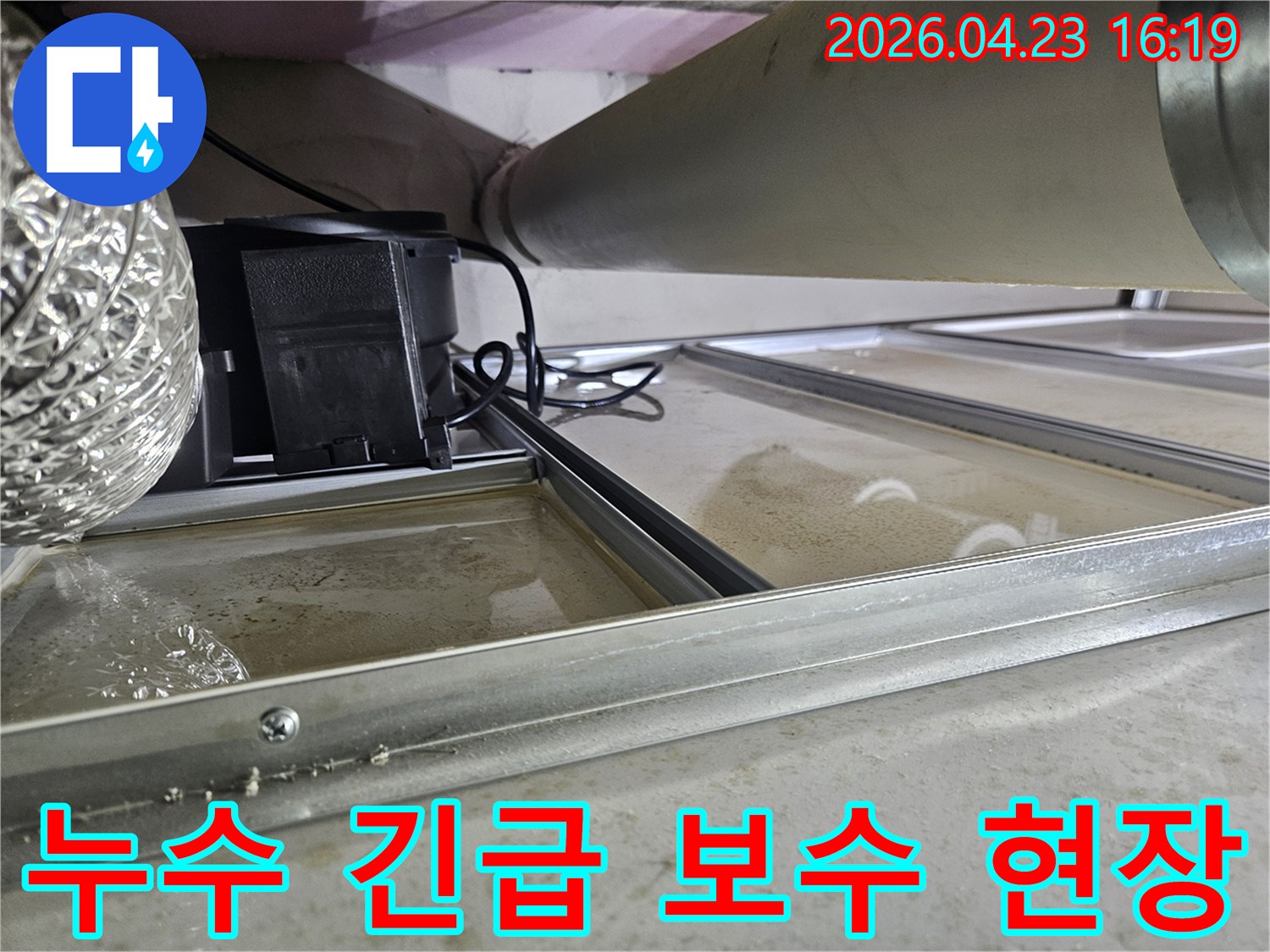 천장 속 배관에서 누수가 발생하여-물이 고여있는 심각한 현장으로-긴급 보수가 필요한 상황을 보여줍니다