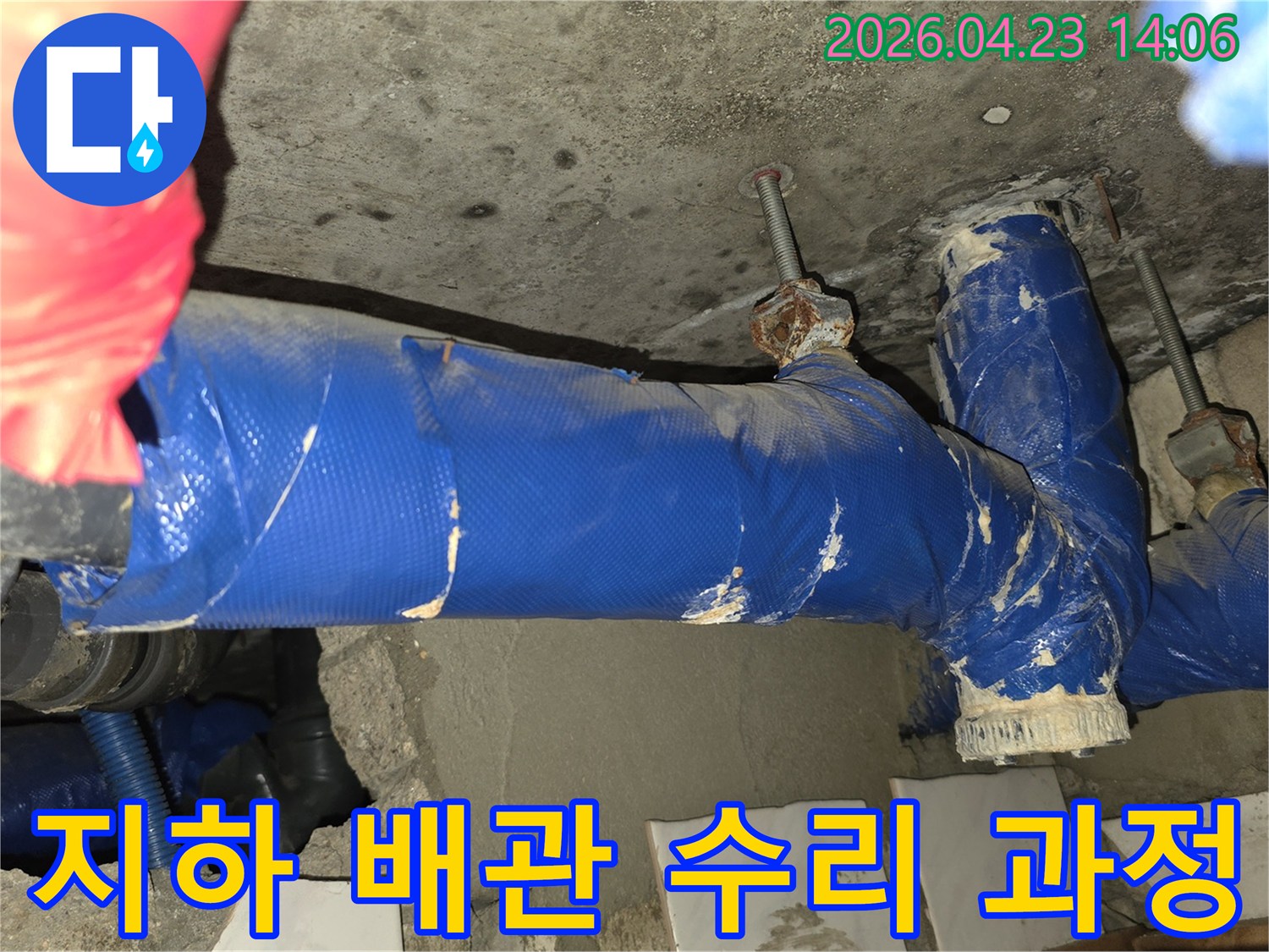 지하 공간의 오래된 배관에서 발생한 누수를-전문가가 수리하는 현장의 생생한 모습입니다.