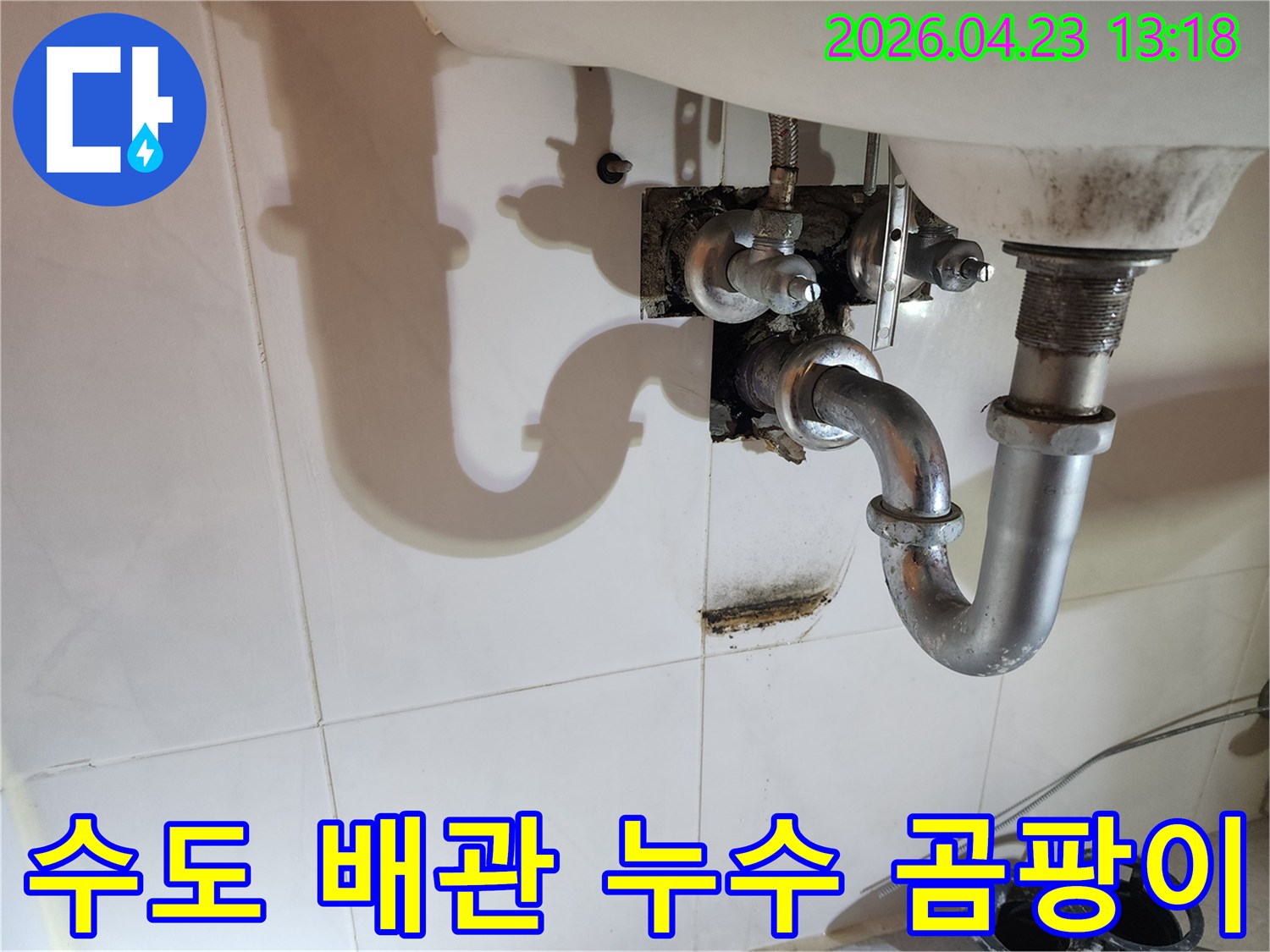 양주 삼숭동 아파트 화장실 세면대 아래 수도 배관에서 발생한-누수로 인해 벽면에 생긴 곰팡이와 물자국을 보여주는 이미지입니다.