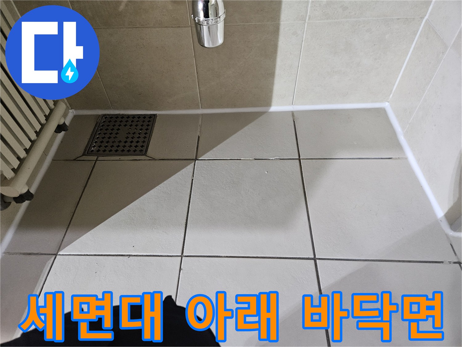 세면대-하부-바닥-타일-및-배수구-근접-촬영