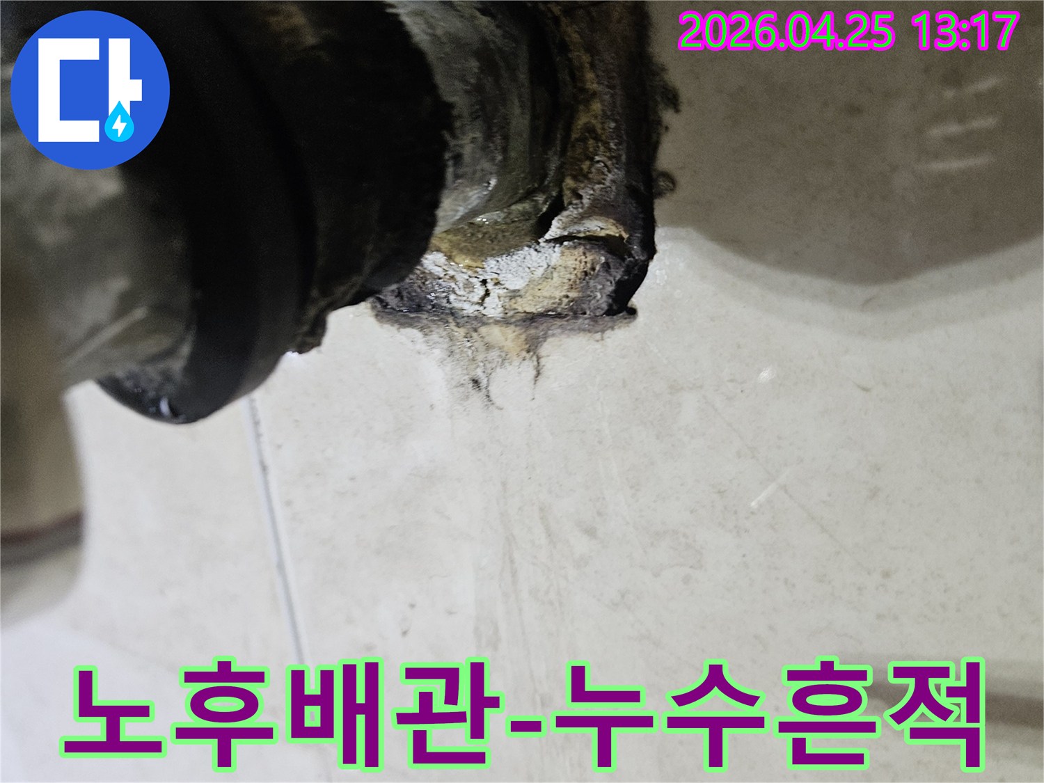 오래된 배관의 연결 부위에서 물이 새어 나와 주변이 심하게 손상된 상태를 보여주는 이미지입니다-전문적인 진단과 보수가 필요합니다.
