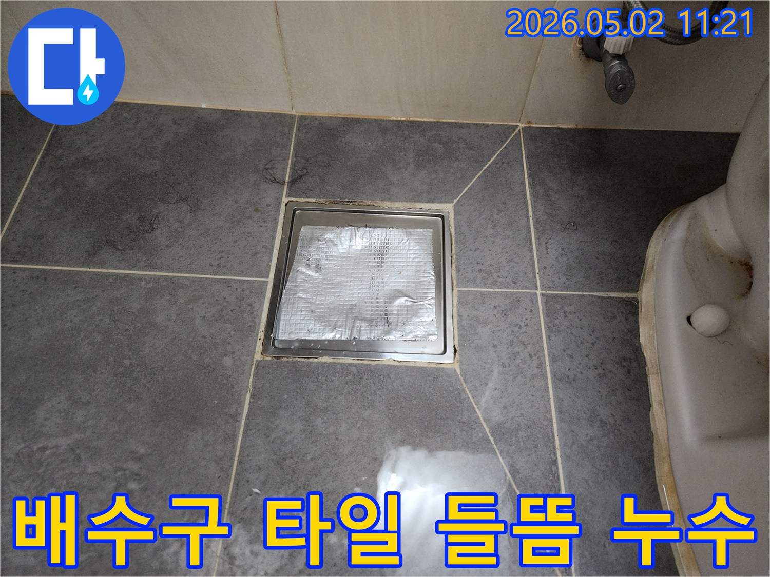 욕실 배수구 주변의-타일 들뜸 현상으로-인한 누수 문제를-점검하고 해결하는-과정의 한 장면입니다.