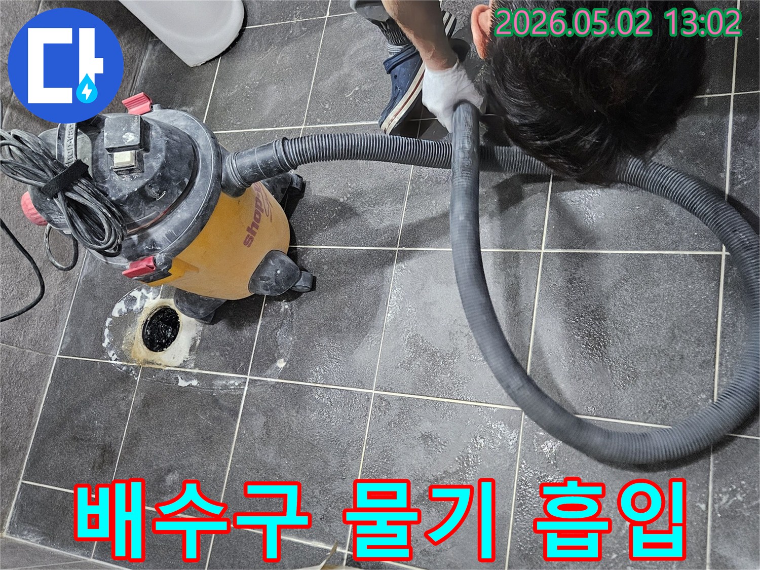 누수 보수 작업 전-배수구 주변의 물기를-습식 청소기로 제거하는 모습
