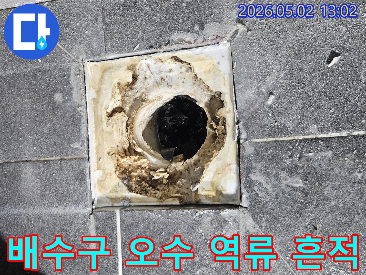 욕실 배수구 주변에-오수 역류로 인해-발생한 오염 흔적을-보여주는 현장 사진입니다