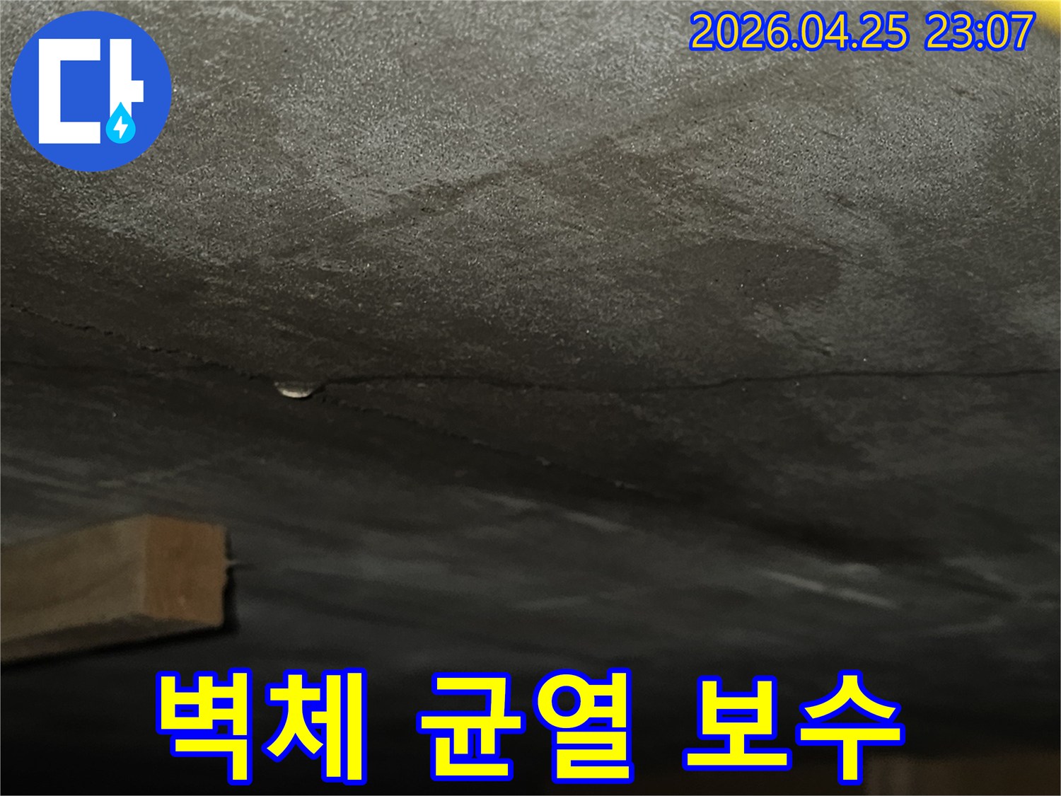 벽면에 생긴 균열을 따라 물기가 스며들어 어둡게 변색된-누수 현장의 상세 모습으로-보수 작업이 필요한 상황