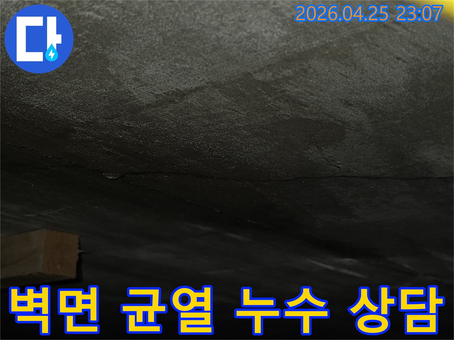 어두운-벽면에-발생한-수직-균열을-통한-누수-현장을-확인하고-전문-상담을-위해-촬영한-사진